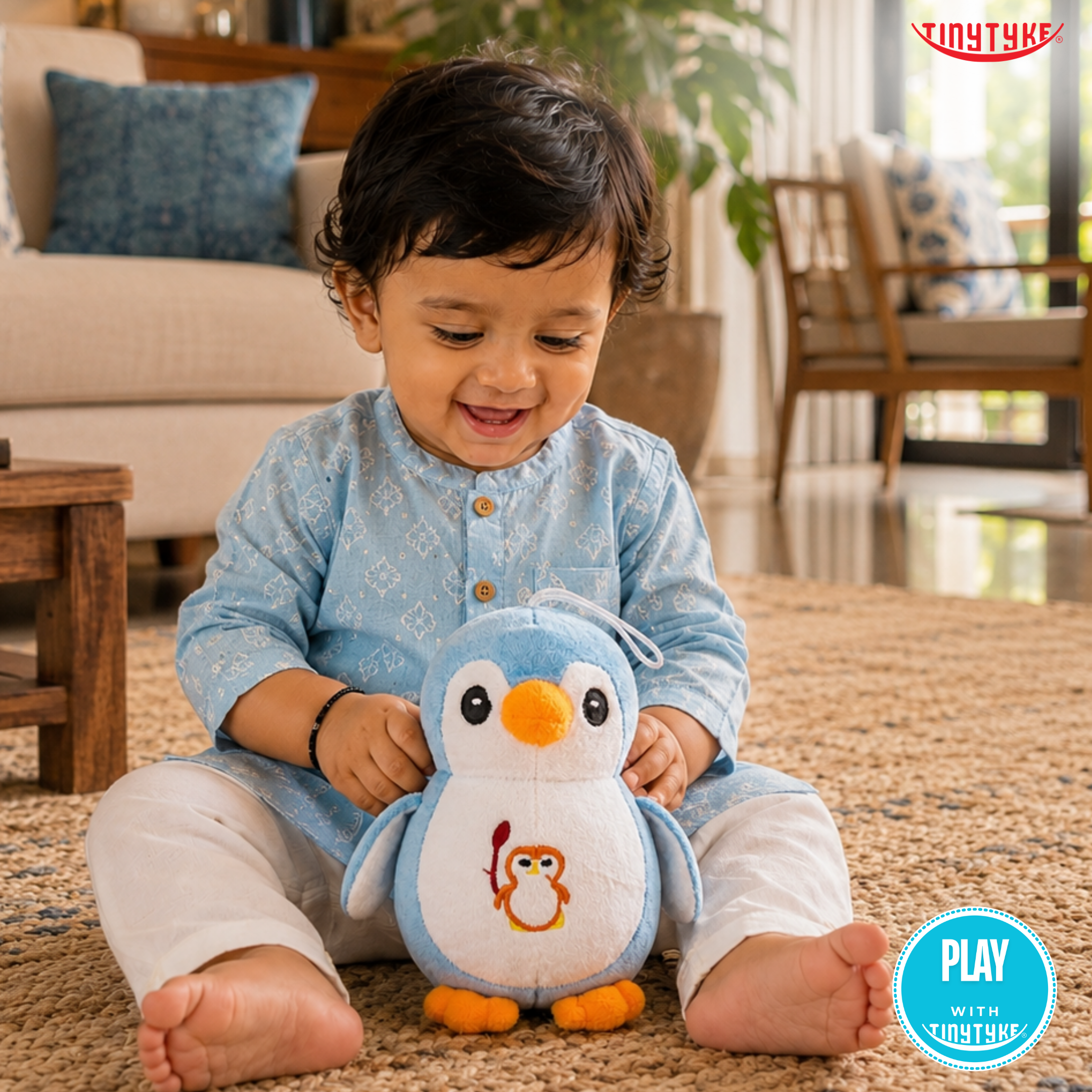 Child holding a TinyTyke — Plush Baby Penguin Soft Toy in a living room setting