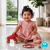 Baby in a pink dress playing with a red Wooden Pull-along Horse Toy indoors